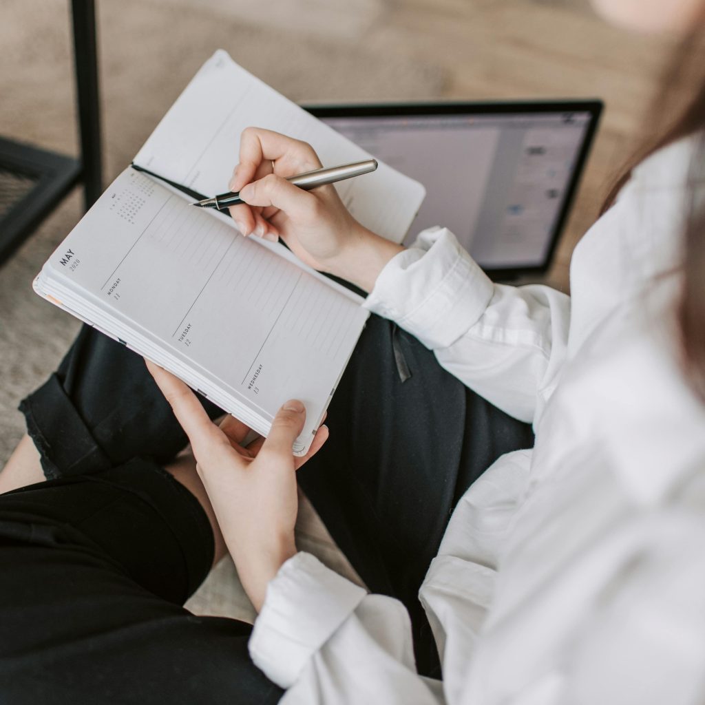 Une jeune fille écrit assise en séance de psychopédagogie ou en cours de français